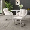 Two beige dining chairs with silver legs are placed in a modern dining room setting. Náhľad obrázku produktu