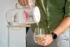 A person is pouring water from a filter pitcher into a glass with a lemon slice. Náhled obrázku produktu