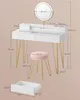 A white vanity table with gold legs and a pink stool, with dimensions overlaid on the image. Produktbild-Vorschau