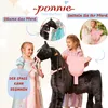Two young girls interacting with a large plush horse toy, one is putting a pink saddle on it, and the other is holding its reins. The image is framed by marketing text and smaller inset images showing close-ups of the horse's head and the saddle. Anteprima dell’immagine prodotto