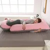 A woman is sleeping on a large J-shaped pregnancy pillow on a bed. Náhled obrázku produktu