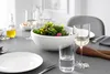 A table setting with a salad bowl, plates, cutlery, and wine glasses. Náhľad obrázku produktu