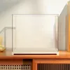 A clear acrylic display case with a white base sits on a wooden surface. Podgląd zdjęcia produktu