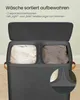 A close-up view of a two-compartment laundry basket with a lid open, showing light and dark laundry inside. A magnified inset highlights the 'Light' and 'Dark' labels on the frame. Podgląd zdjęcia produktu