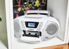 A white Blaupunkt boombox with a cassette tape inserted is placed on a white shelf, with a colorful book in the background. Produktbild-Vorschau