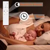 A mother and baby sleeping in bed, with a remote control and feature callouts. Náhled obrázku produktu