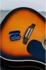 A pair of blue wireless earbuds in their case rests on the body of an acoustic guitar. Produktbild-Vorschau