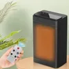 A hand holding a remote control is positioned in front of a black electric heater, with a plant in the background. Produktbild-Vorschau