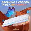 A white keyboard is displayed with large blue and smaller blue butterflies, along with flowing orange fabric, against a blue sky background. Text overlays the image. Produktbild-Vorschau
