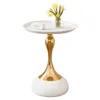 A white round side table with a gold metallic base and a vase of yellow tulips and a white object on top. Produktbild-Vorschau