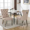 Two beige upholstered dining chairs with silver legs are placed in front of a marble-topped dining table in a well-lit room. Podgląd zdjęcia produktu