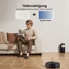 A man is sitting on a couch reading a book while a robot vacuum cleaner operates on the floor, demonstrating cleaning paths. Produktbild-Vorschau