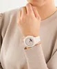 A person wearing a light beige sweater and a white watch. Produktbild-Vorschau