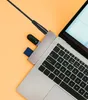 A close-up view of a laptop with a USB hub and several devices plugged into it. Voir les images du produit