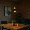 A dining table with a pendant light hanging above it, in a room with a sofa and artwork. Podgląd zdjęcia produktu
