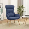 A blue fabric armchair is placed on a beige rug in a well-lit room, next to a potted plant and a small white table. Podgląd zdjęcia produktu