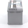 A side view of a gray car battery with labels on top. Produktbild-Vorschau