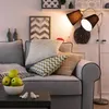 A living room scene with a sofa, pillows, and a floor lamp. Náhled obrázku produktu