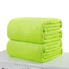 Two folded green blankets stacked on top of each other on a white surface. Produktbild-Vorschau