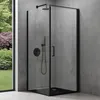 A modern black framed shower cabin with a shower head and controls, set against a textured gray wall and a window showing a garden. Produktbild-Vorschau