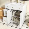 A white bathroom vanity with its doors and drawers open, revealing storage space filled with toiletries and towels. The vanity has a ceramic sink and gold-colored hardware. The floor is tiled with a black and white pattern. Anteprima dell’immagine prodotto