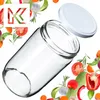 A clear glass jar with a white lid is shown, surrounded by various fresh vegetables and herbs. Podgląd zdjęcia produktu