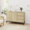 A light wood sideboard with black legs is shown in a well-lit room with a window and curtains in the background. Voir les images du produit