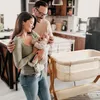 A family with a newborn baby in a kitchen setting, with a bedside crib nearby. Náhled obrázku produktu