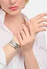 A close-up of a woman's wrist wearing silver bangles, with her other hand resting gently on top. Produktbild-Vorschau