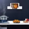 A kitchen scene with a tablet mounted on the wall displaying a recipe, a pot cooking on a stove, and a plate of food. Produktbild-Vorschau