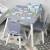 A children's table and two chairs set with a memory game on the table, placed on a rug in a room. Produktbild-Vorschau