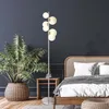 A bedroom scene with a floor lamp, a bed, and a plant. Produktbild-Vorschau