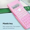 A pink scientific calculator is shown on a desk with books. Náhled obrázku produktu