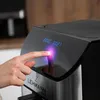 A person's hand touches the digital display of a black and silver air fryer. Náhled obrázku produktu