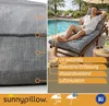 A man relaxing on a lounge chair with a cushion by a swimming pool. Produktbild-Vorschau