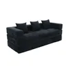 A black modular sofa with three throw pillows, shown from a three-quarter angle against a white background. Produktbild-Vorschau