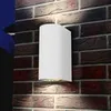 A white outdoor light fixture mounted on a brick wall. Náhled obrázku produktu