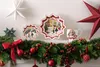 Christmas decorations on a mantelpiece, including plates, a mug, and a garland. Náhled obrázku produktu