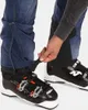A person is adjusting the gaiter of a pair of ski pants over a ski boot. Produktbild-Vorschau