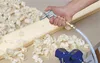 A hand holding a blow gun attached to a hose, blowing wood shavings off a piece of wood that is clamped in a blue vise. Produktbild-Vorschau