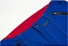 A close-up view of the waistband and zipper of blue work pants with a red lining. Produktbild-Vorschau