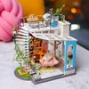 A miniature dollhouse model of a multi-story building with a spiral staircase and rooftop terrace. Anteprima dell’immagine prodotto