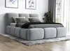 A modern upholstered bed with a headboard and footboard, placed on a rug in a bedroom setting. Produktbild-Vorschau