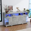 A modern gray sideboard with blue LED lighting, displayed in a well-lit room with a window view of the ocean. Produktbild-Vorschau