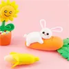 Clay models of a sunflower in a pot, a bunny on a carrot, and a banana on a pink background. Náhled obrázku produktu