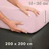Hands are shown adjusting a pink fitted sheet on a mattress. Produktbild-Vorschau