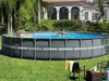 Two people relaxing in an above-ground swimming pool in a backyard setting. Produktbild-Vorschau
