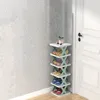 A multi-tiered shoe rack filled with shoes, placed in a corner next to a white door. The wall has a textured pattern. Produktbild-Vorschau