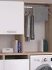 A laundry room cabinet with clothes hanging and cleaning supplies on shelves. Produktbild-Vorschau