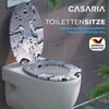 A toilet seat and lid with a water drop design, displayed on a toilet in a bathroom setting. Anteprima dell’immagine prodotto